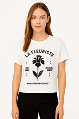 Remera blanca de manga corta con estampa de flor negra, texto y números.