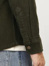 Sobrecamisa verde oscuro de pana con cierre de botones, manga larga y bolsillos en el pecho.