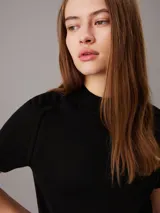 Sweater negro de punto fino con cuello perkins y mangas cortas.
