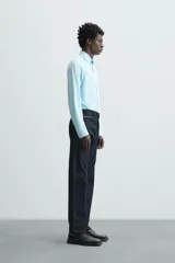 Camisa negra de manga larga con cuello italiano abierto y cierre frontal de botonadura. Corte slim fit.