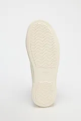 Zapatillas bajas de denim azul oscuro con cordones blancos y suela de plataforma color crema.