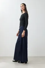 Pantalón de jean wide leg color azul oscuro con cintura alta y cinturón de cadena plateada.