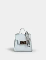 Monedero de cuerina celeste con forma de bolso pequeño, manija superior, solapa con broche de botón y mosquetón lateral con cadena plateada.