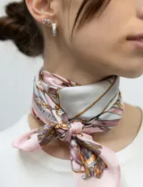 Pañuelo cuadrado de satén con estampado de cadenas doradas y detalles en rosa y blanco.