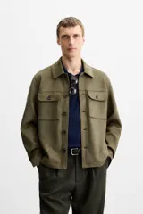 Sobrecamisa color beige de corte recto, con cuello solapa, manga larga con puños abotonados, cierre frontal abotonado, bolsillos de parche con solapa en el pecho y bolsillos de ojal en la cadera.