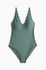 Traje de baño entero color verde con escote en V festoneado, breteles ajustables y copas con relleno extraíble. Cobertura media en la parte de atrás y forro completo.