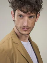 Blazer azul marino de corte clásico, con solapa de muesca, cierre de dos botones, bolsillo de parche en el pecho y bolsillos con solapa en los laterales.