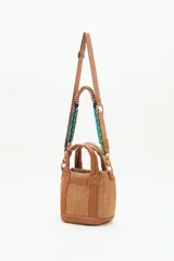 Cartera tote mini color negro, confeccionada en tejido tipo rafia. Cuenta con bolsillos internos, dos correas desmontables y abertura superior con cierre.