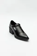 Zapato tipo T-bar de charol negro con hebilla lateral y taco ancho.