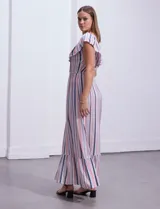 Vestido largo de modal estampado a rayas verticales en tonos azul, rojo, blanco y gris. Tiene cuello redondo con volados y cintura elastizada.