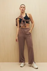 Pantalón de calce ancho color marrón, con cintura elastizada, bolsillos laterales y corte recto con abertura en el ruedo.