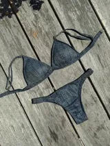 Conjunto de bikini azul con estampado a cuadros. El corpiño es de triángulo fijo con breteles regulables y almohadillas desmontables. La bombacha es vedetina con frunce elástico en los costados.