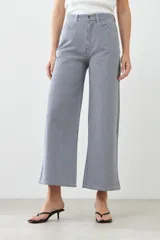 Pantalón de jean a rayas verticales azules y blancas, de corte amplio y tiro alto.