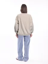 Buzo color beige con estampado de flores y texto en blanco.
