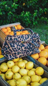 Bolso tote con estampado animal print, con doble asa corta y correa fina con hebilla.