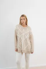 Sweater de mohair color crema con diseño de telaraña bordado a mano en negro.