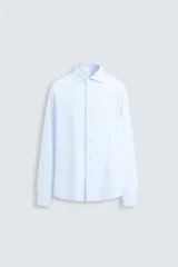 Camisa celeste a rayas verticales blancas, de corte recto, con cuello italiano abierto, mangas largas con puños abotonados y cierre frontal con botones.