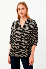 Blusa con estampado abstracto en tonos beige y negro, escote en V y mangas 3/4.
