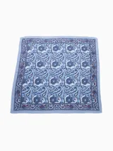 Pañuelo cuadrado de poliéster color celeste con estampado de motivos geométricos y florales en tonos azules, grises y borgoña.