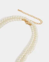 Collar largo de perlas sintéticas color blanco.
