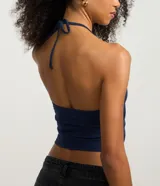 Blusa cropped de frente única color crema, confeccionada en algodón con elastano, con escote en V y lazo en el cuello.