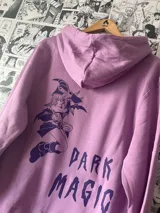 Canguro lila con capucha y bolsillo delantero. Estampa circular con símbolos mágicos en el pecho.