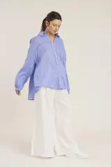 Camisa blanca de manga larga, corte holgado, con cuello camisero y detalles de bordados perforados (calado) verticales en el frente.