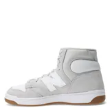 Championes de caña alta New Balance modelo 480, color gris y blanco, confeccionados en gamuza y cuero, con logo "N" característico en los laterales y suela de goma color caramelo.