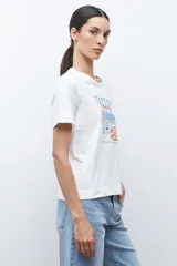 Remera blanca de manga corta con cuello redondo y un estampado frontal que simula una barra de café o té con el texto "TEA D'CLOCK".