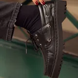 Mocasín negro de cuero con plataforma track y cordones.