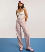 Pantalón femenino de sarga color rosa pálido, modelo baggy de cintura mediana, con trabillas, cierre tradicional y cinco bolsillos. Confeccionado con algodón certificado BCI.