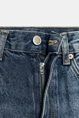 Jeans de tiro alto, estilo balloon leg, largo completo. Denim azul oscuro con efecto lavado y cinco bolsillos.