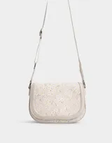 Bandolera con solapa de cuerina estampada con flores. Tiene correa regulable desmontable de algodón y cierre con broche a presión.