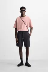 Camiseta rosa de corte recto, cuello redondo y manga corta. Estampado con efecto grabado combinado a tono en la espalda.
