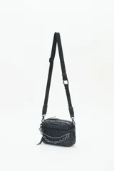 Bandolera negra de nylon matelassé con correa regulable, avíos metálicos, llavero de corazón y dijes desmontables.