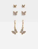 Set de tres pares de aros dorados con forma de mariposa: un par de aros tipo botón con mariposas lisas, un par de aros tipo botón con mariposas con incrustaciones de strass y un par de aros colgantes con mariposas con incrustaciones de strass.