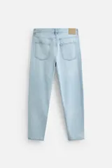Pantalón de jean celeste de corte slim fit y tapered, con cinco bolsillos, efecto lavado y cierre frontal con cremallera y botón.