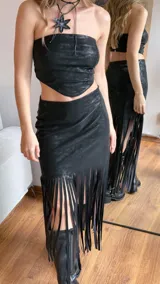 Minifalda negra con flecos largos en el ruedo.