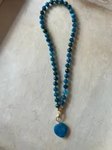 Collar de cuentas de colores con dije de corazón.