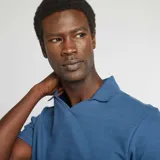 Remera azul de punto de piqué con cuello polo en V y mangas cortas.