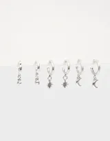 Set de tres pares de aros tipo argolla bañados en plata, con dijes colgantes: luna creciente, estrella de ocho puntas y strass.