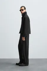 Pantalón negro de corte recto, con cintura elástica, bolsillos laterales y trasero.