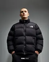 Campera puffer The North Face, color gris y negro, con cierre frontal y cuello alto. Logo de la marca bordado en el pecho.