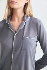 Pijama de viscosa y poliamida color gris con ribetes blancos, compuesto por camisa de manga larga con botones y pantalón largo.