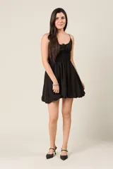 Vestido corto celeste con breteles finos, escote fruncido con lazo y falda con corte globo.