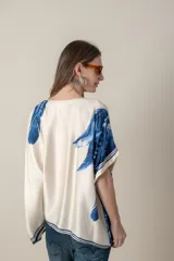Blusa italiana color natural con estampado de hojas en tonos azules. De calce holgado y talle único.