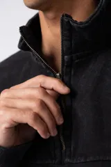 Buzo negro de frisa 100% algodón con medio cierre y bordado al tono. Tiene un lavado snow que le da un look gastado.