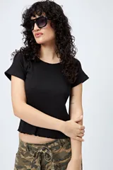Remera color beige de punto acanalado con silueta relajada y manga corta raglán. El ruedo tiene terminación ondulada. El tejido con elasticidad ligera brinda comodidad y movimiento.