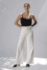 Crop top negro con breteles finos y escote con tiras cruzadas.