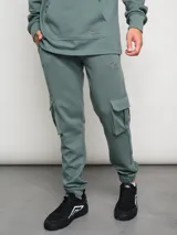Pantalón de jogging gris con bolsillos cargo laterales y logo de la marca bordado en la pierna.